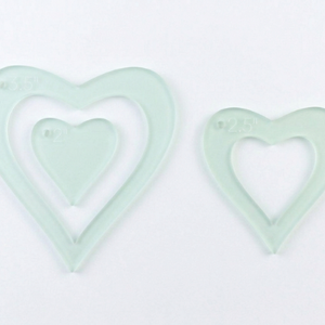 A close up on three acrylic heart sewing and craft templates 