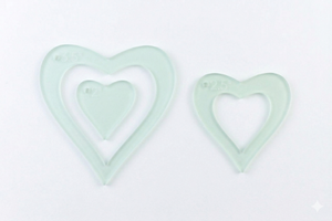 A close up on three acrylic heart sewing and craft templates 