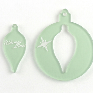 a close up of two acrylic bauble templates 